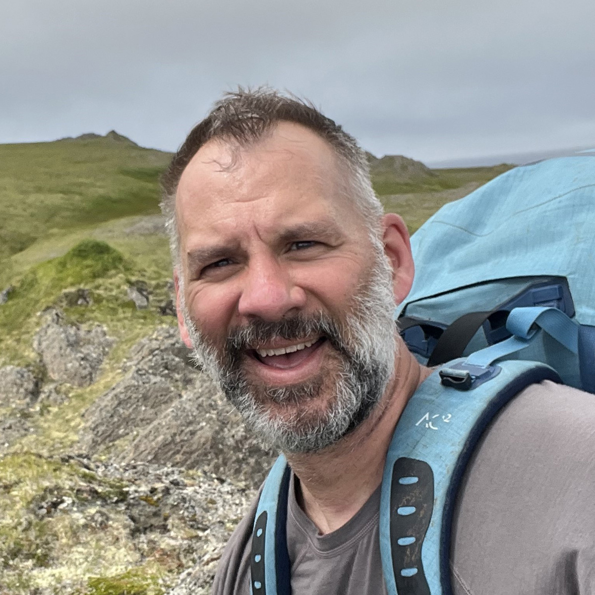 Matt Carlson taking a selfie while hiking in alpine tundra.