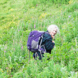 Photo of Sandy Talbot. Sandy is standing in a field of tall plants.